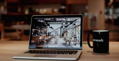 a laptop with a coffee cup