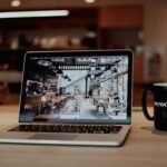 a laptop with a coffee cup